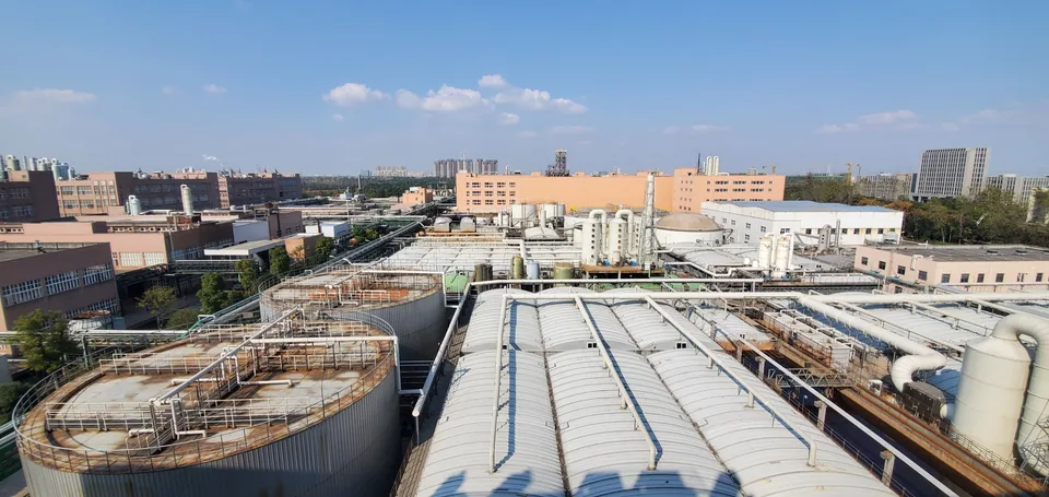 Industrial wastewater treatment facility with tanks, covered basins, and process piping