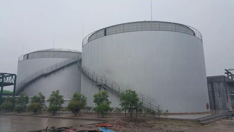 Large anaerobic treatment tanks with external access stairs at the Baihehua wastewater-treatment site